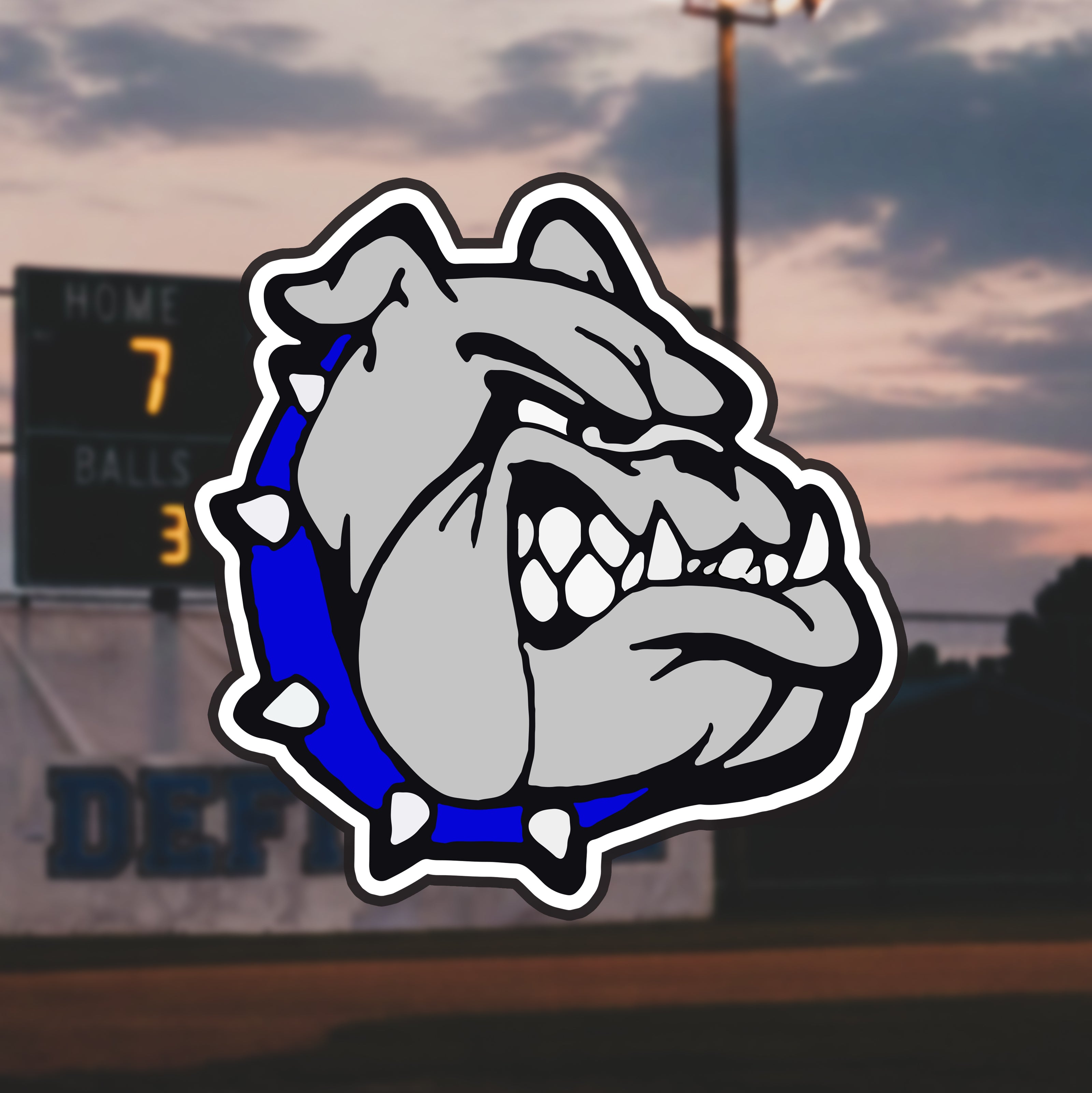 Bulldog logo with a sunset sky and ball field in the background